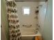 Bright bathroom featuring a tub with tiled walls, shower, and a decorative shower curtain at 5730 16Th Ne Ln, St Petersburg, FL 33703