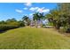 Expansive lawn and backyard featuring palm trees, tiki hut and large home with balconies at 6785 Burning Tree Dr, Seminole, FL 33777