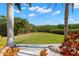 Expansive backyard featuring a manicured lawn, mature trees, and access to a lush green space at 6785 Burning Tree Dr, Seminole, FL 33777