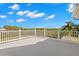 Expansive balcony with white railings offering panoramic views of lush greenery and blue skies at 6785 Burning Tree Dr, Seminole, FL 33777