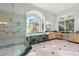 Bright, open bathroom with a glass shower, tub with a window view, and granite countertops at 6785 Burning Tree Dr, Seminole, FL 33777