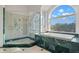Luxurious bathroom featuring a glass shower, tub with a view, and green marble accents at 6785 Burning Tree Dr, Seminole, FL 33777