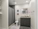 Cozy bathroom with a gray vanity, sleek mirror, and a shower featuring modern tile at 6785 Burning Tree Dr, Seminole, FL 33777