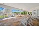 Inviting covered patio with travertine floors, exterior stairs and white Adirondack chairs create a relaxing outdoor space at 6785 Burning Tree Dr, Seminole, FL 33777