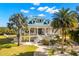 Stunning two-story home with white facade, blue roof, and tropical landscaping at 6785 Burning Tree Dr, Seminole, FL 33777