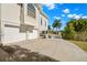 Side view of home showing two-car garage and well-maintained landscaping and blue sky background at 6785 Burning Tree Dr, Seminole, FL 33777