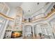 An open foyer features a stone column, hardwood floors, iron railings, and views of a sitting room with great natural light at 6785 Burning Tree Dr, Seminole, FL 33777