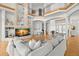 Spacious living room with soaring ceilings, fireplace, a two-story stone column, hardwood floors, and comfortable seating at 6785 Burning Tree Dr, Seminole, FL 33777