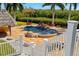 Stunning pool area with a waterfall feature, lush landscaping, and a tiki bar at 6785 Burning Tree Dr, Seminole, FL 33777