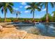 Stunning pool with a rock waterfall and lush landscaping, creating a private oasis at 6785 Burning Tree Dr, Seminole, FL 33777
