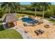 Resort style pool with rock features, waterfall, tiki hut, and sun loungers at 6785 Burning Tree Dr, Seminole, FL 33777