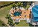 Aerial detail of backyard pool with spa, fire pit, seating area, and tiki hut at 6785 Burning Tree Dr, Seminole, FL 33777