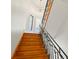 Wooden staircase with wrought iron railings, illuminated by natural light from nearby windows at 6785 Burning Tree Dr, Seminole, FL 33777