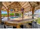 Charming tiki bar with a thatched roof, sink, and seating, perfect for poolside entertaining at 6785 Burning Tree Dr, Seminole, FL 33777