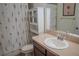 Cozy bathroom features floral shower curtain, vanity, and mirrored cabinet at 18311 Arbor Crest Dr, Hudson, FL 34667