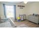 Well-lit Bedroom showcases a crib, changing table, and gray dresser, creating an organized space at 18311 Arbor Crest Dr, Hudson, FL 34667