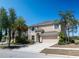 Charming two-story home with a well-manicured lawn, palm trees, and attached two-car garage at 18311 Arbor Crest Dr, Hudson, FL 34667