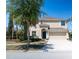 Charming two-story home with a well-manicured lawn, palm trees, and attached two-car garage at 18311 Arbor Crest Dr, Hudson, FL 34667