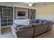 Comfortable living room with a large gray sectional sofa, custom wall features, and light wood flooring at 18311 Arbor Crest Dr, Hudson, FL 34667