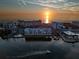 Stunning aerial view of waterfront condos at sunset with a boat cruising by, tennis courts and calm waters at 18325 Gulf Blvd # 405, Redington Shores, FL 33708