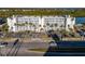 Bright condominium building with rows of palm trees and parking in front, near a wide road at 18325 Gulf Blvd # 405, Redington Shores, FL 33708