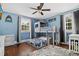 Charming bedroom with light blue walls, wood floors, bunk beds, and bright natural light from two large windows at 319 26Th W St, Bradenton, FL 34205