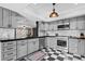 Modern kitchen with stainless steel appliances, black countertops, grey cabinets, and checkerboard flooring at 319 26Th W St, Bradenton, FL 34205