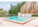Relaxing community swimming pool surrounded by paved area, tiki hut, and well-maintained landscaping at 4732 Lake Blvd # A, Clearwater, FL 33762