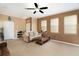 Spacious living room with neutral carpet, ceiling fan, and plenty of natural light at 9111 Moonlit Meadows Loop, Riverview, FL 33578