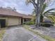 Charming home featuring a stone facade and mature landscaping with a large, shaded front yard at 9888 Lake Seminole E Dr, Largo, FL 33773