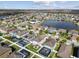 Expansive aerial view of a residential area with a tranquil lake, showcasing neatly arranged homes with pools and green spaces at 12408 Victarra Pl, New Port Richey, FL 34655