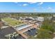 This aerial view showcases the community's shuffleboard courts, parking, recreation area, and proximity to the golf course at 1311 Caloosa Lake Ct, Sun City Center, FL 33573