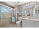 Charming bathroom with striped wallpaper, vanity, and shower with decorative glass block window at 1311 Caloosa Lake Ct, Sun City Center, FL 33573