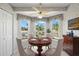 Cozy dining area with a round table, chandelier, bay windows and views of the outdoors at 1311 Caloosa Lake Ct, Sun City Center, FL 33573