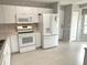 Bright kitchen with white appliances, tiled floors and ample countertop space for cooking and entertaining at 1311 Caloosa Lake Ct, Sun City Center, FL 33573