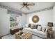 Cozy living room featuring a plush sofa, patterned rug, and ceiling fan providing a comfortable space at 1311 Caloosa Lake Ct, Sun City Center, FL 33573