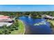 Picturesque aerial view of the community lake featuring a beautiful fountain and lush landscaping at 15856 Cobble Mill Dr, Wimauma, FL 33598