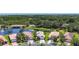 Aerial view of homes near a lake, with neatly landscaped yards and a lush tree line backdrop at 15856 Cobble Mill Dr, Wimauma, FL 33598