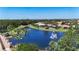 Scenic aerial view of houses around a tranquil lake with a fountain and lush palm trees at 15856 Cobble Mill Dr, Wimauma, FL 33598