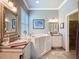 Bright primary bathroom features a walk-in tub, double sinks, and tile floor at 15856 Cobble Mill Dr, Wimauma, FL 33598