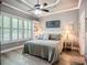 Neutral bedroom with tray ceiling, plantation shutters, and ensuite bath at 15856 Cobble Mill Dr, Wimauma, FL 33598