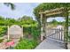 View of the entrance to the community garden with raised garden beds and lush greenery at 15856 Cobble Mill Dr, Wimauma, FL 33598