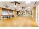 Bright fitness room with wood floors, ceiling fans, mirrors, and storage shelves at 15856 Cobble Mill Dr, Wimauma, FL 33598