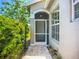 Inviting front entrance with a decorative door, sidelight windows, and a well-maintained garden at 15856 Cobble Mill Dr, Wimauma, FL 33598