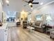 Spacious living room showcasing hardwood floors, comfortable seating, and seamless access to the kitchen at 15856 Cobble Mill Dr, Wimauma, FL 33598