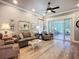 Bright living room featuring hardwood floors, stylish furniture, a decorative mirror, and access to a sunroom at 15856 Cobble Mill Dr, Wimauma, FL 33598
