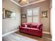 Cozy living room with red sofa, plantation shutters, and wood floors at 15856 Cobble Mill Dr, Wimauma, FL 33598