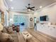 Cozy living room featuring hardwood floors, stylish furniture, ceiling fan, and access to a sunroom at 15856 Cobble Mill Dr, Wimauma, FL 33598