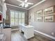 Bright office space features a white desk, built-in shelving, and plantation shutters at 15856 Cobble Mill Dr, Wimauma, FL 33598