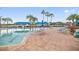 Beautiful community pool with lounge chairs, tables, and shaded seating areas at 15856 Cobble Mill Dr, Wimauma, FL 33598